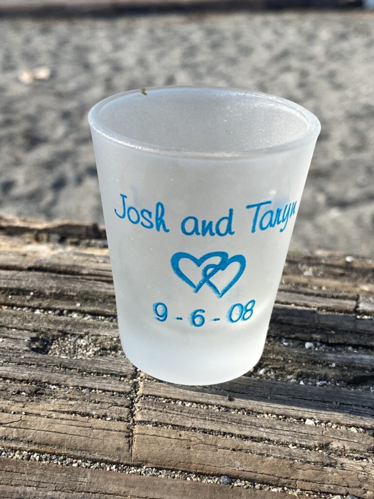 2008 shot glass wedding favor with painted lettering in blue: traces of Arsenic & Lead. Safe by all standards.